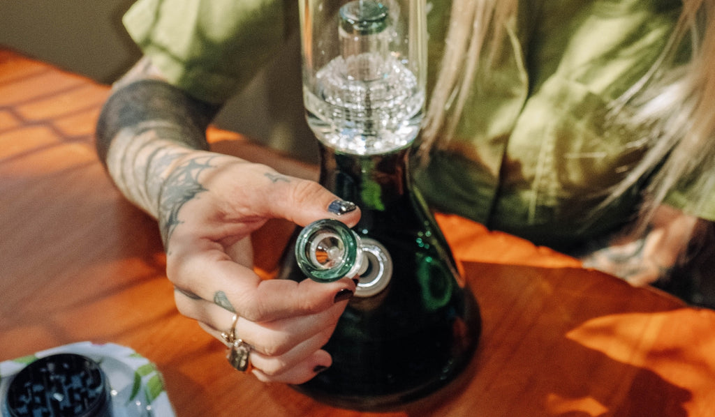 A person disassembling their glass bong