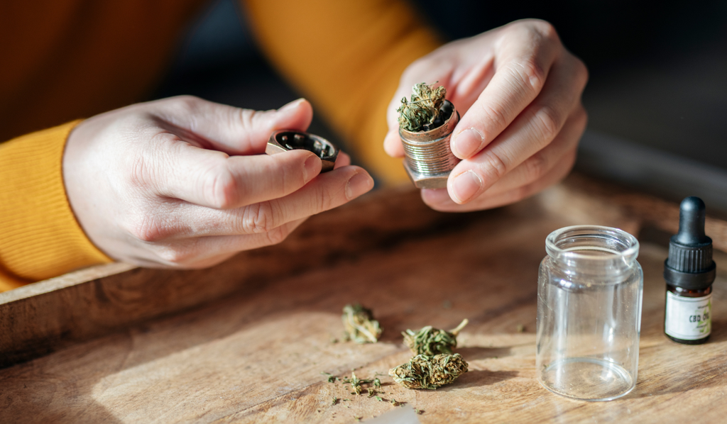 A person grinding their cannabis with a grinder