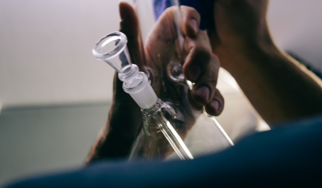 A person holding a glass bong