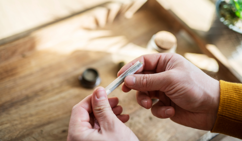 A person tightening a rolled joint