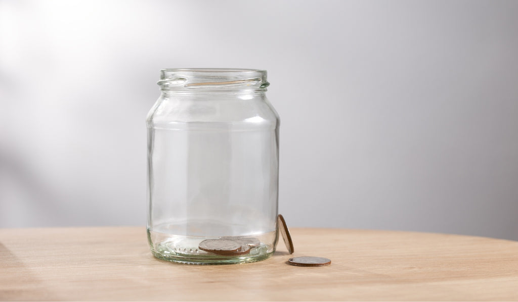 An empty glass bottle with a coin