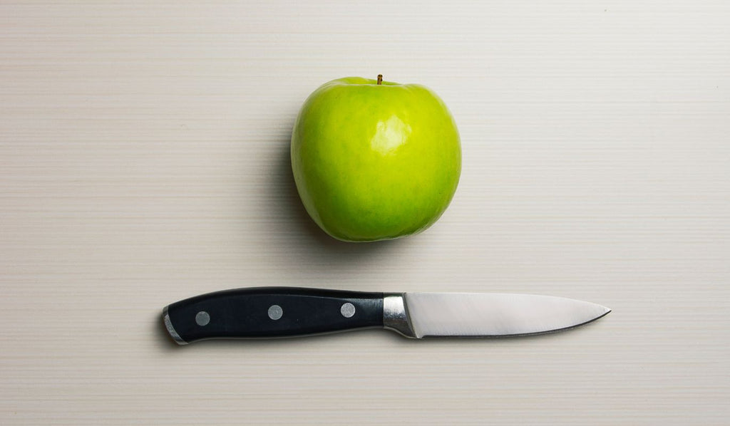 Green apple with a knife