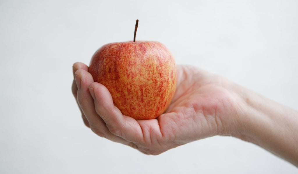 Hand grasping apple