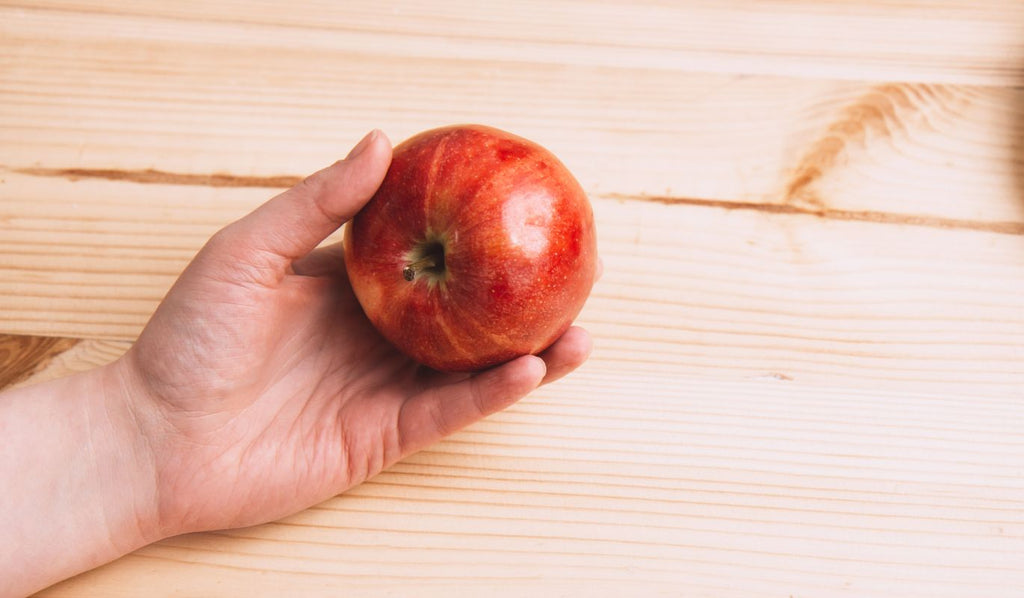 Hand holding a red apple