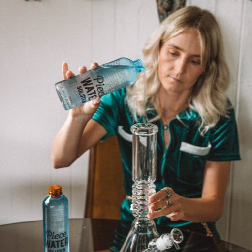 Woman pouring Piece Water Solution into glass beaker bong