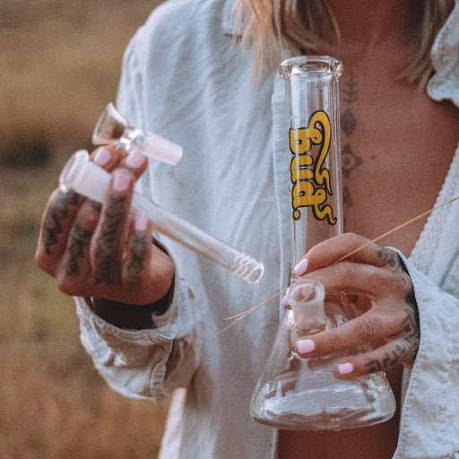 Woman holding glass beaker bong