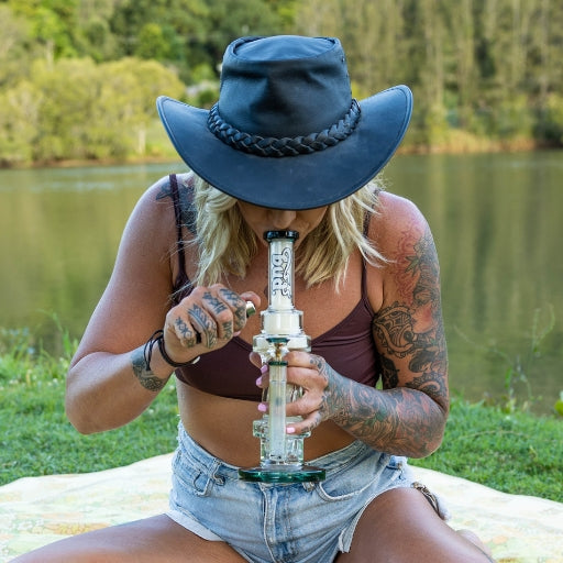 Woman smoking from a glass percolator bong