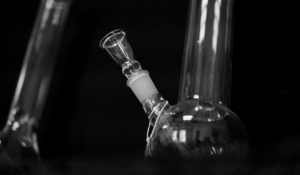 Two glass bongs on a black background